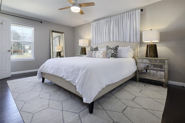 bedroom featuring ceiling fan, baseboards, and wood finished floors