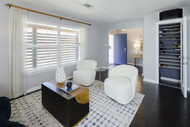 living room with visible vents, baseboards, and wood finished floors