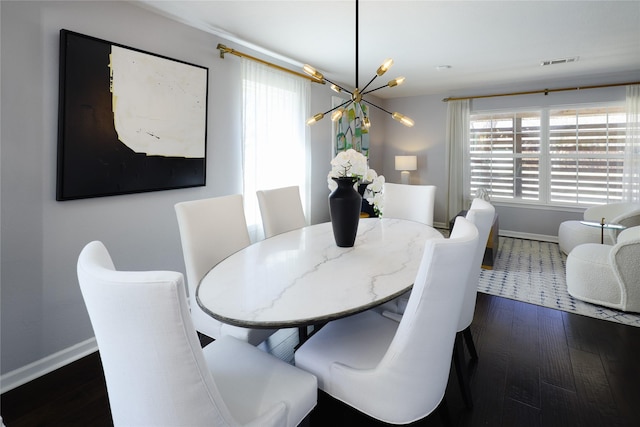 dining room featuring a notable chandelier, visible vents, dark wood-type flooring, and baseboards