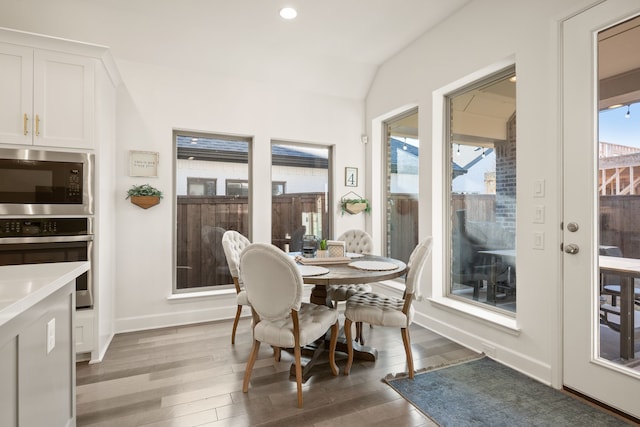 dining area with recessed lighting, baseboards, light wood-type flooring, and lofted ceiling