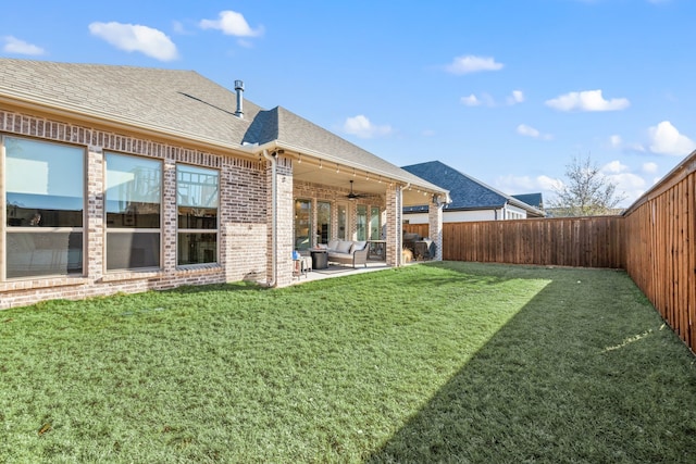 view of yard with a fenced backyard, a patio area, and a ceiling fan