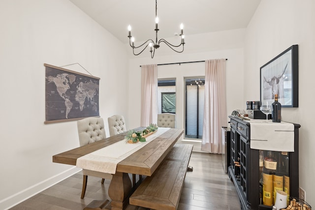 dining room featuring a notable chandelier, baseboards, and wood finished floors