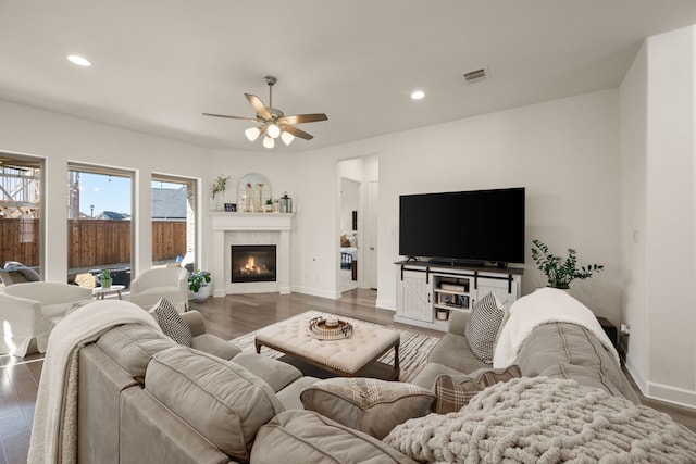 living room with visible vents, wood finished floors, recessed lighting, baseboards, and a tile fireplace