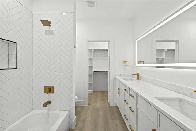 full bath featuring a sink, visible vents, wood finished floors, and double vanity