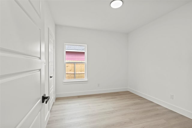 spare room with light wood-type flooring and baseboards