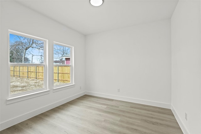 empty room with baseboards and light wood-type flooring