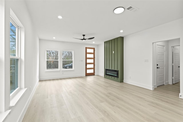 unfurnished living room featuring light wood finished floors, visible vents, baseboards, recessed lighting, and a fireplace