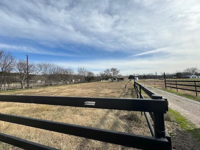 view of yard with a rural view and fence