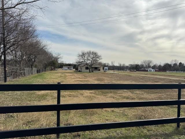 view of yard featuring a rural view and fence