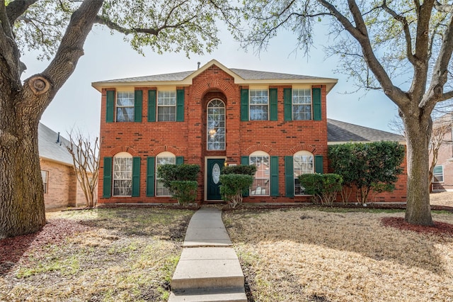 colonial inspired home featuring brick siding