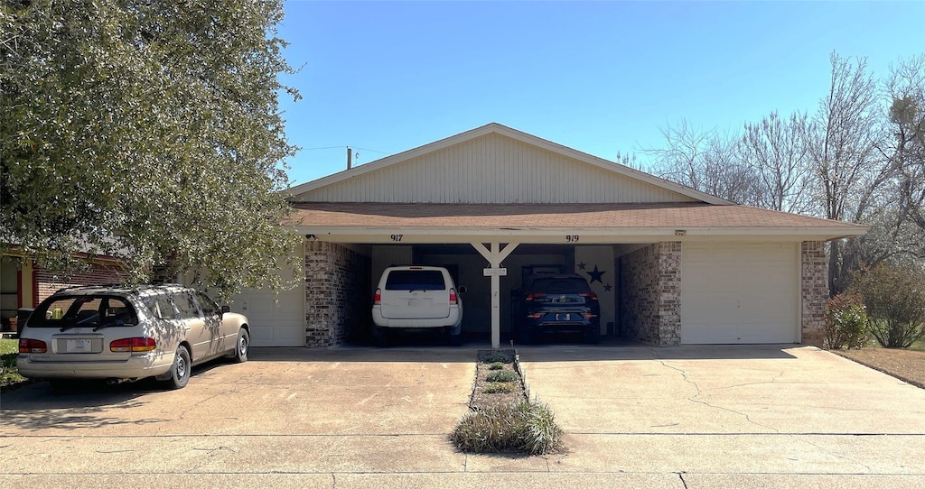 view of front of property with brick siding, driveway, and a garage