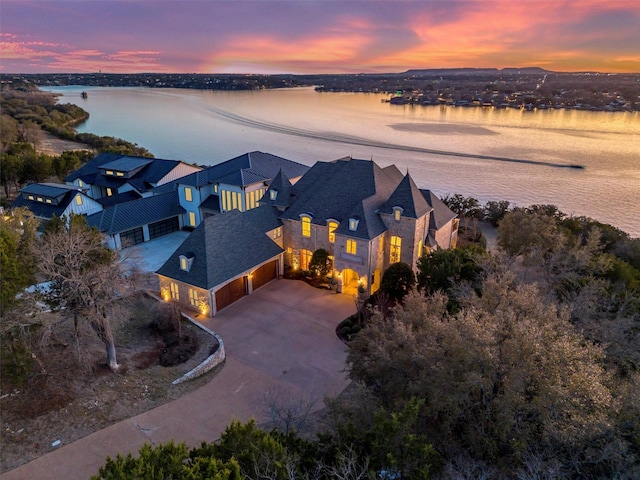 aerial view at dusk featuring a water view