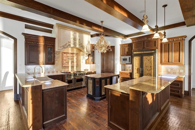 kitchen with a sink, light stone counters, dark wood-style floors, a center island, and built in appliances