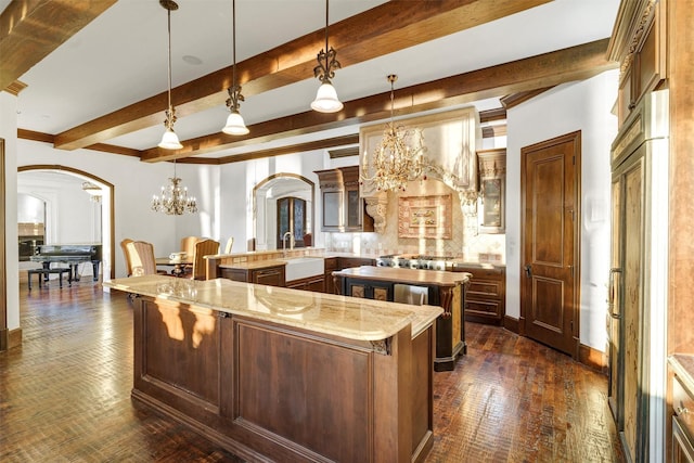 kitchen with arched walkways, a large island, and an inviting chandelier