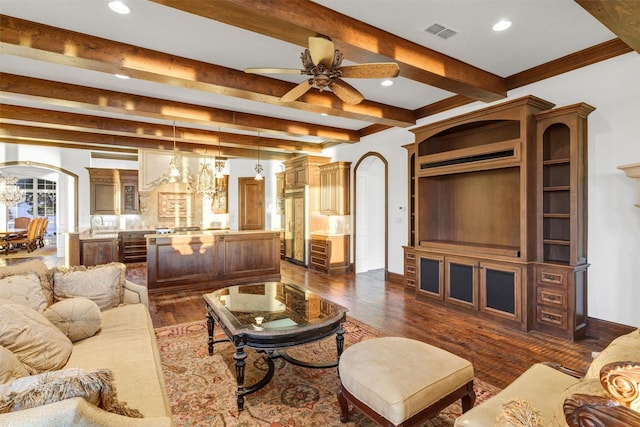 living room featuring visible vents, arched walkways, dark wood-style flooring, ceiling fan, and beamed ceiling