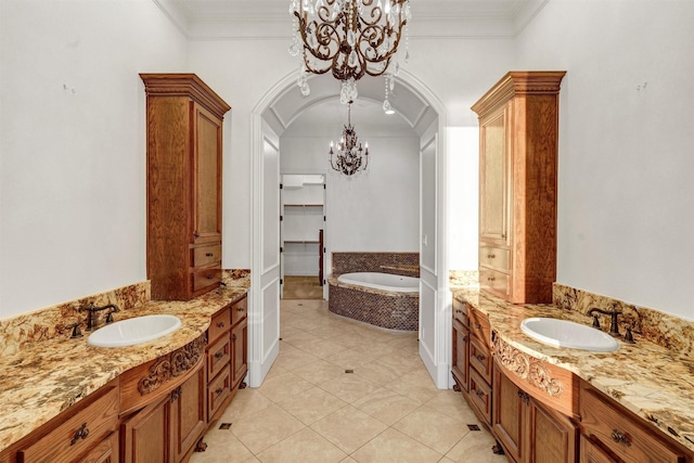 full bath with ornamental molding, an inviting chandelier, and a sink