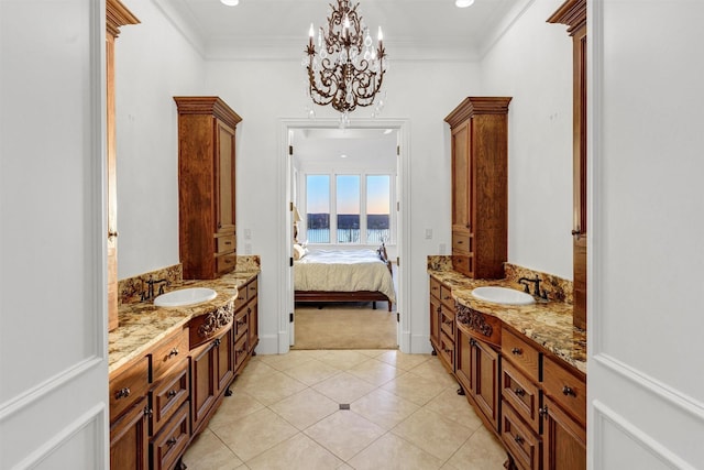 full bath with tile patterned floors, crown molding, two vanities, and a sink