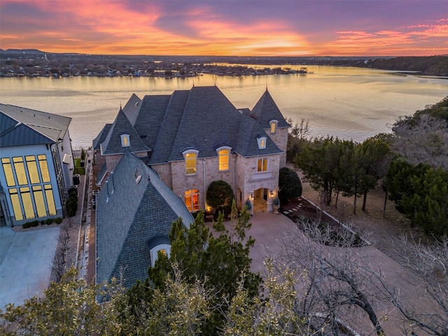 exterior space featuring stone siding and a water view