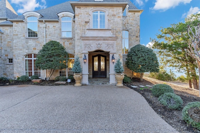 french country home featuring french doors and a high end roof