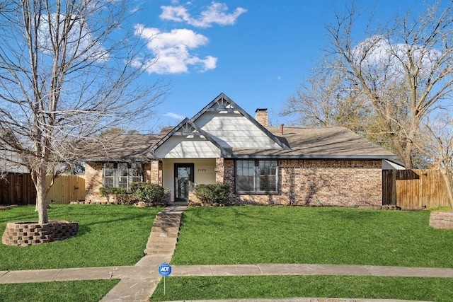 view of front of property featuring brick siding, a front lawn, and fence