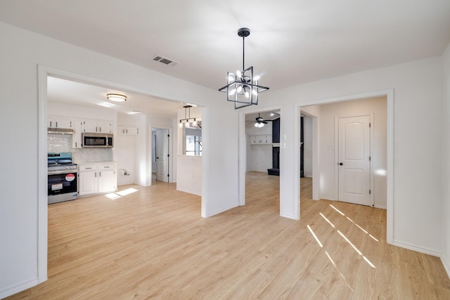 unfurnished dining area featuring baseboards, visible vents, light wood finished floors, and ceiling fan