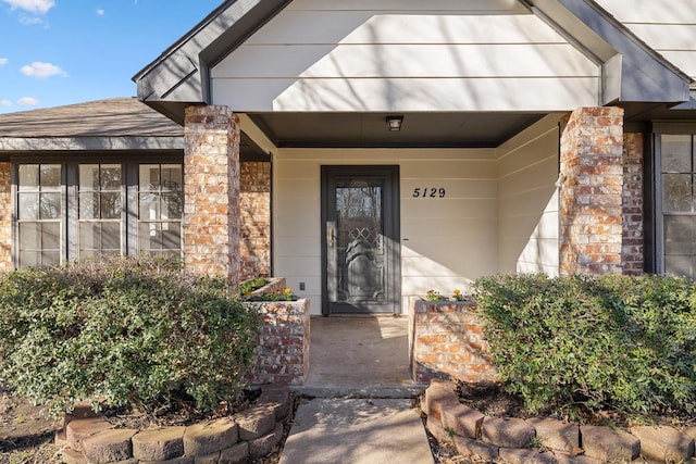 entrance to property featuring brick siding and a porch