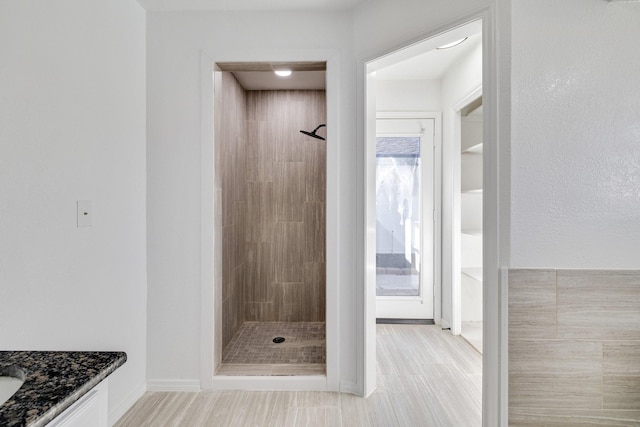 full bathroom featuring wood finished floors, a stall shower, and vanity