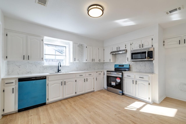 kitchen with under cabinet range hood, visible vents, appliances with stainless steel finishes, and a sink