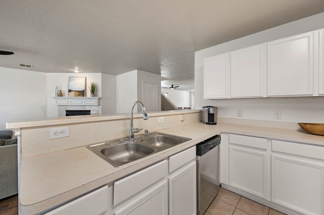 kitchen featuring a peninsula, a sink, a textured ceiling, dishwasher, and open floor plan