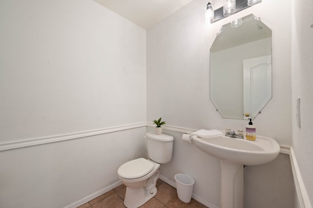 bathroom featuring tile patterned flooring, toilet, and baseboards