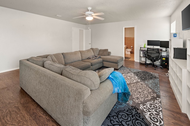 living room featuring baseboards, a textured ceiling, wood finished floors, and a ceiling fan