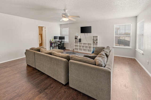 living area featuring baseboards, a textured ceiling, wood finished floors, and a ceiling fan