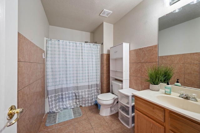 full bathroom featuring visible vents, tile patterned flooring, a textured ceiling, tile walls, and toilet