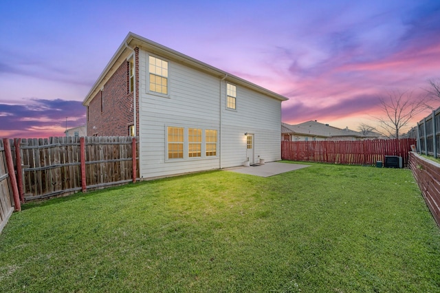 rear view of house with a patio, a fenced backyard, a yard, brick siding, and central AC unit