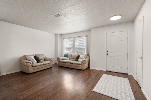 living room with visible vents, a textured ceiling, dark wood-type flooring, and baseboards