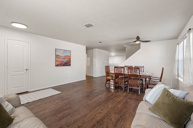 living room with wood finished floors, baseboards, visible vents, ceiling fan, and a textured ceiling