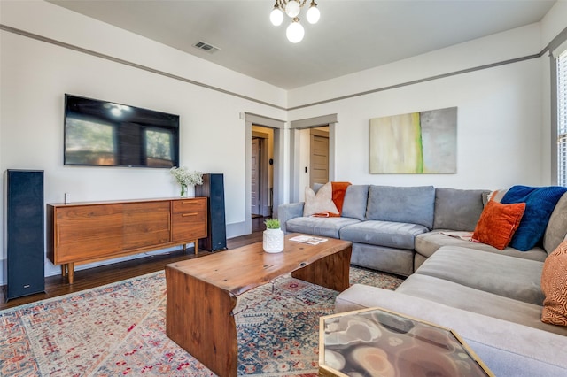 living area with visible vents and wood finished floors