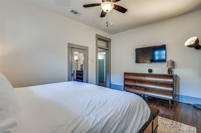 bedroom with wood finished floors, visible vents, and ceiling fan