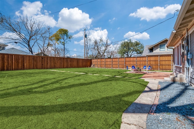 view of yard featuring entry steps, a fenced backyard, and a patio