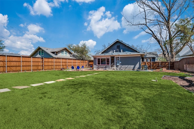 back of house featuring a yard, a fenced backyard, and a patio area