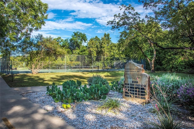 view of yard with a tennis court and fence