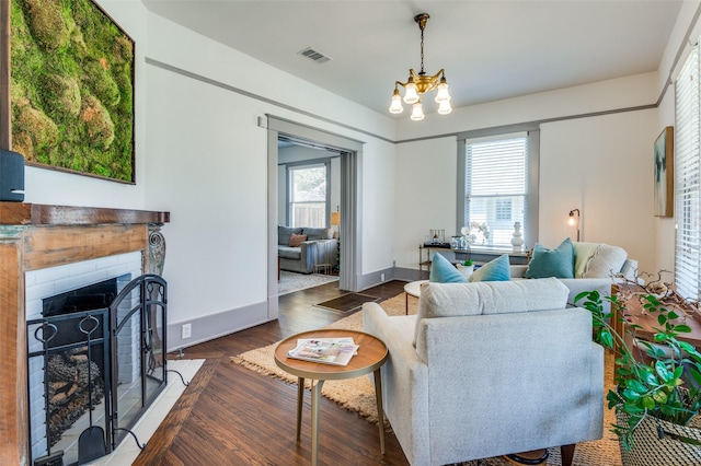 living room with a fireplace, plenty of natural light, wood finished floors, and visible vents