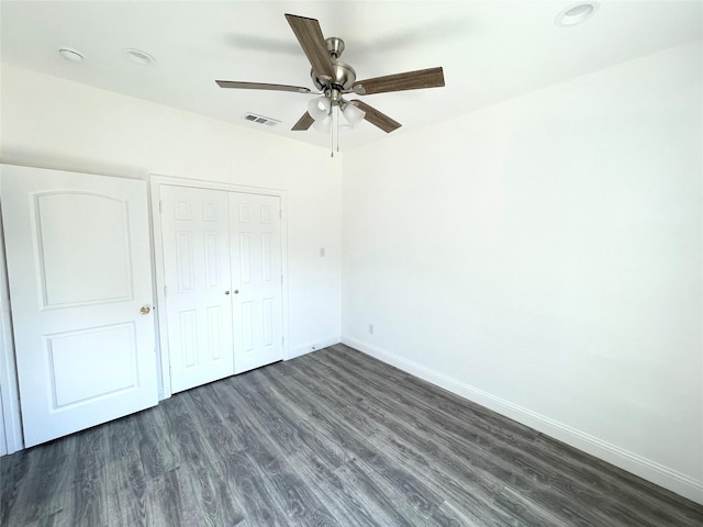 unfurnished bedroom featuring visible vents, ceiling fan, baseboards, a closet, and dark wood-style flooring