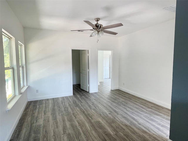 spare room featuring baseboards, dark wood-style flooring, and ceiling fan