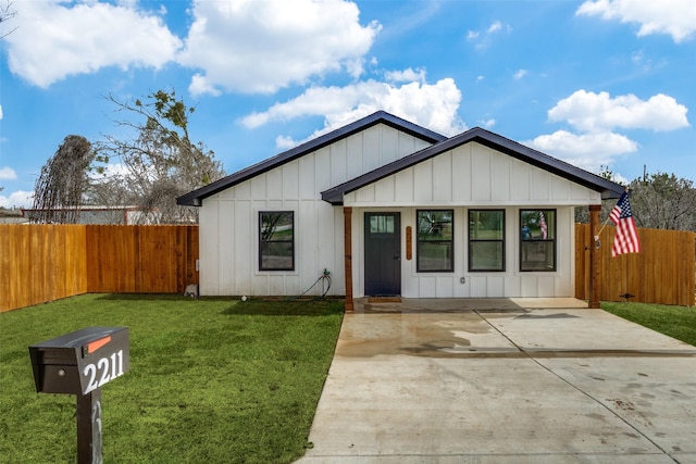 view of front facade featuring a front yard, fence, and board and batten siding