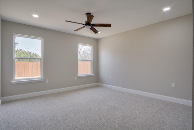 spare room with recessed lighting, baseboards, light colored carpet, and a ceiling fan