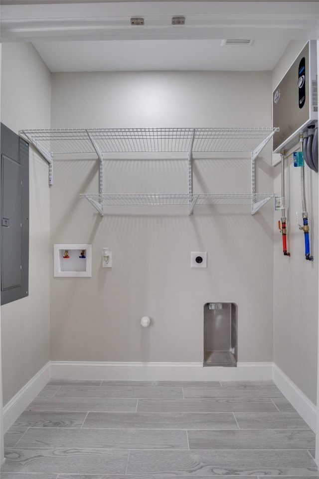 clothes washing area with wood tiled floor, hookup for an electric dryer, hookup for a washing machine, and laundry area