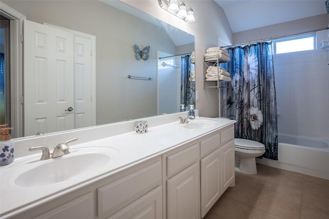 bathroom with tile patterned flooring, vaulted ceiling, toilet, and a sink