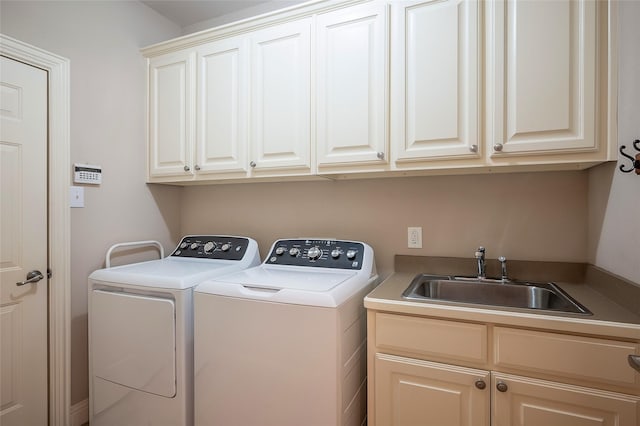 clothes washing area featuring a sink, cabinet space, and washing machine and dryer