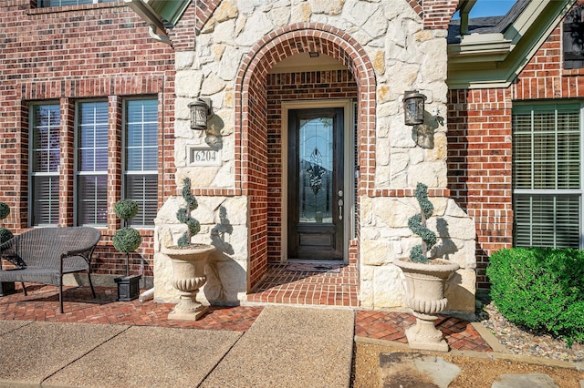 property entrance with brick siding and stone siding